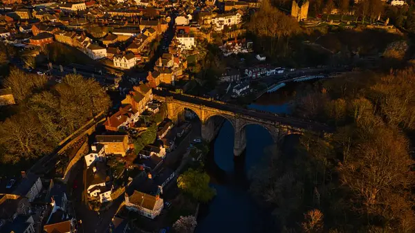 İngiltere 'nin Knaresborough kentinde, binalar ve ağaçlarla çevrili taştan bir demiryolu viyaoluğunun bulunduğu bir kasabanın havadan görünüşü..