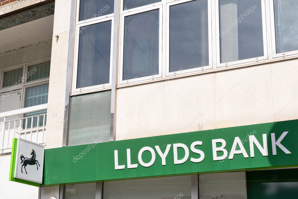 A partial view of a Lloyds Bank building, featuring the sign, windows, and adjacent building detail in daylight  in Kingston, UK.