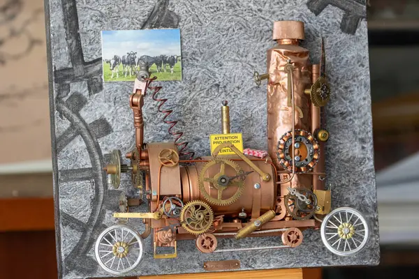 Steampunk tarzı tren heykeli. Metal ve bakır, bir inek fotoğrafıyla, desenli, Fransa 'nın Giverny şehrinde vites motifiyle boyanmış..