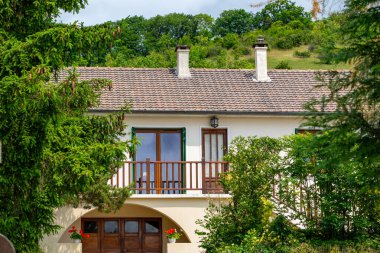 Seramik çatılı, iki katlı bir ev. Giverny, Fransa 'da her iki tarafında ağaçlar olan küçük bir balkon görülebilir..