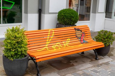 A vibrant orange bench with the word 