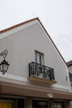 Fransa 'nın La Vallee Köyü' nde bulutlu bir günde balkonlu bir binanın ön cephesinin alçak açılı görüntüsü..