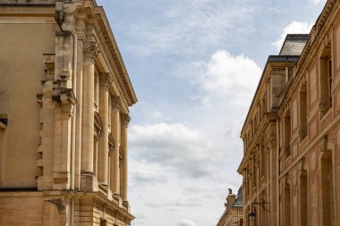 Versailles Gardens, Paris 'te bulutlarla dolu bir gökyüzünü çerçeveleyen sütunlu iki binanın mimarisi.