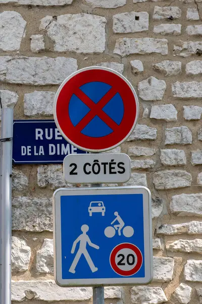 Fransa 'nın Giverny kentindeki açık renkli taşlardan yapılmış bir duvarın önündeki metal bir direğe 