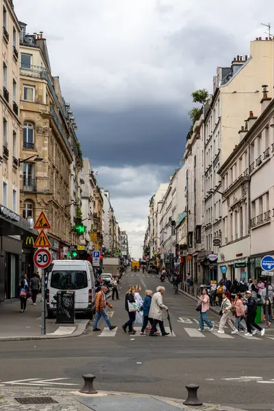Avrupa 'nın bir şehrinde yaya geçidinde cadde manzarası caddeleri kaplayan binalar ve bulutlu gökyüzü.