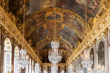 Paris, Versailles Sarayı 'ndaki kemerli camları ve mermer aksanlı büyük salonda boyanmış bir tavan, avizeler ve yaldızlı detaylarla süslü bir iç mekan..
