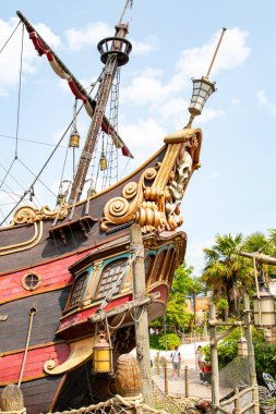Mavi gökyüzü ve Disneyland Paris 'teki tropikal yeşillik karşısında bir korsan gemisinin pruvası, donanımı ve ön direği detaylı bir şekilde görülüyor..