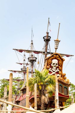 Direkleri, teçhizatı, kafatası ve çapraz kemikleri olan, palmiye ağaçları tarafından çerçevelenmiş, açık mavi gökyüzü altında Disneyland Paris 'te.