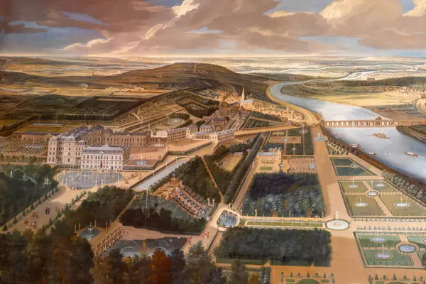 Paris 'teki Versailles Sarayı' nda bulutlu bir gökyüzünün altında büyük bir sarayın, bahçelerin, bir nehrin ve çevrenin havadan görüntüsü..