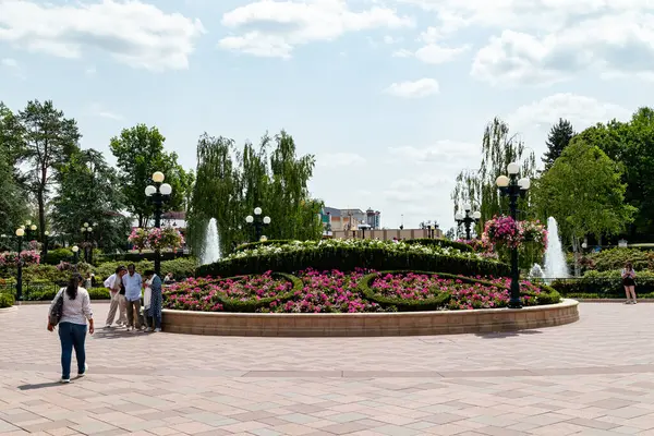 Ağaçlar ve Paris Disneyland 'de desenli tuğlalarla çevrili, insan ve sokak lambalarıyla dolu renkli, manzaralı bir çeşme..