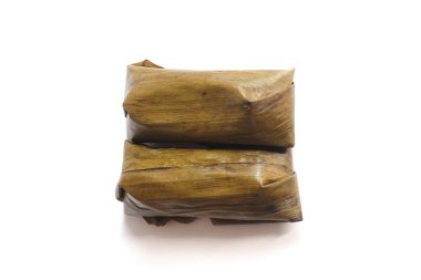 Lontong beyaz arka planda izole edildi. Lontong muz yapraklarına sarılı pilavdır ve kaynar suyun üzerinde saatlerce buharla pişirilir. Lontong, Ramazan ve Ramazan aylarında popüler bir yemektir.