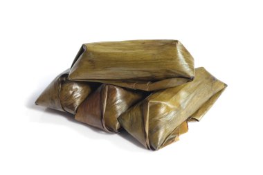 Lontong beyaz arka planda izole edildi. Lontong muz yapraklarına sarılı pilavdır ve kaynar suyun üzerinde saatlerce buharla pişirilir. Lontong, Ramazan ve Ramazan aylarında popüler bir yemektir.