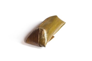 Lontong beyaz arka planda izole edildi. Lontong muz yapraklarına sarılı pilavdır ve kaynar suyun üzerinde saatlerce buharla pişirilir. Lontong, Ramazan ve Ramazan aylarında popüler bir yemektir.