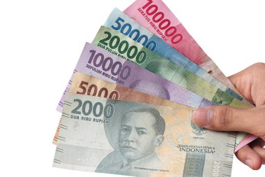 Adamın eli Endonezya rupia banknotlarını tutuyor.