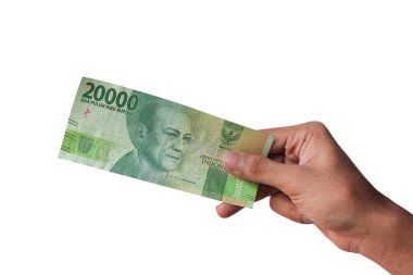 Adamın eli, beyaz arka planda yirmibin rupiayı gösteriyor.