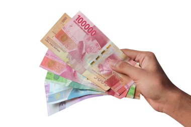 Bir adamın eli, beyaz arka planda izole edilmiş rupiah parasını gösterir. Rupiah, Endonezya 'nın para birimidir.
