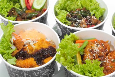 Baharatlı soslu kızarmış tavuk ve beyaz arka planda izole edilmiş sebzeli tavuk katsu. Fast food konsepti