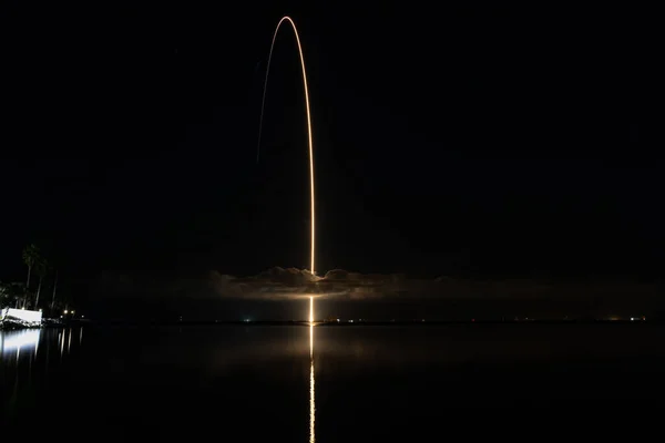 Stunning Rocket Launch: Reflecting off the Water and Through a Cloud