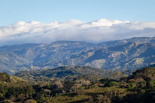 Kosta Rika 'daki San Mateo Dağları' nın geniş manzarası, uzaktaki yemyeşil ormanlar ve bulut katmanlarıyla kaplıdır..