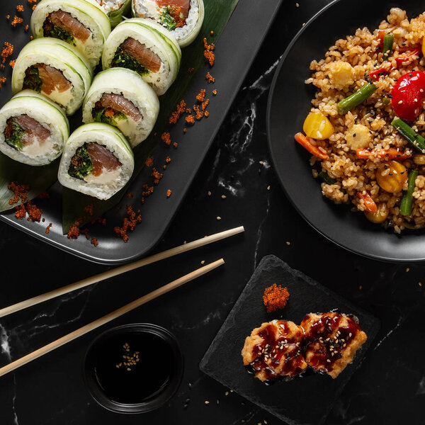 Набор еды азиатского стиля, рис ча хан, рулоны, гунканы, плоский уголок, вид сверху. Высокое качество фото.