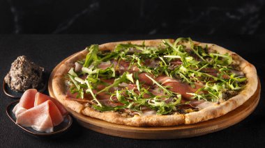 A luxurious truffle pizza topped with delicate slices of prosciutto, fresh arugula, and rich truffle sauce on a golden, crispy crust.  clipart