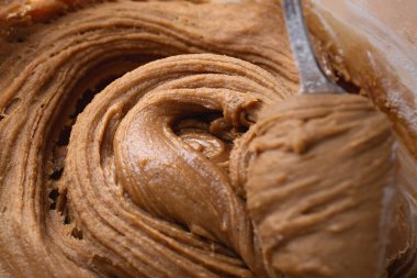 Kalın zencefilli kurabiye hamuru kaşık ya da spatula ile kaldırılıyor, elastik dokuyu ve ayrıntılı girdapları gösteriyor. Tatil pişirmeyi göstermek için ideal..