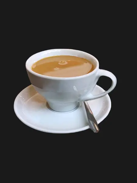 Sütlü, beyaz bir fincan çay kaşığıyla koyu arkaplanda beyaz bir fincan kahve. Metin için boşluk