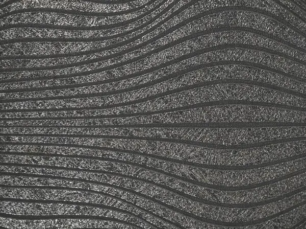 Gümüş dalgalı çizgiler şeklinde desenli duvar cephesi. Basit bir arka plan. Yakın plan.