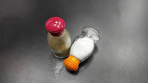 Tahtadaki cam kavanozda tuz ve biber.