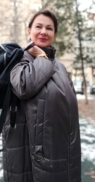 60 yaşın üzerinde Avrupa uyruklu bir kadın sırt çantasıyla yürüyüşe çıkmış.