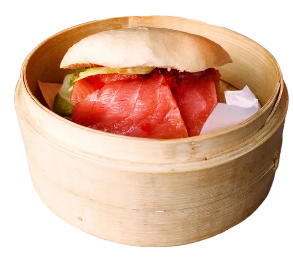 Somon burgeri bambu buharlı, modern Asya füzyon gıda konseptinde servis edilir. Doğal ışıklandırmalı ahşap masaya yakın çekim..