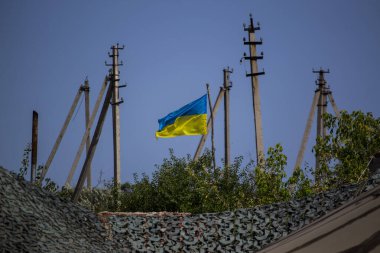 Elektrik direkleri arasında dalgalanan Ukrayna ulusal bayrağı bağımsızlığı, vatanseverliği ve dayanıklılığı simgeliyor.
