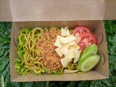 Bir kase erişte ve sebzenin yakın çekimi. 