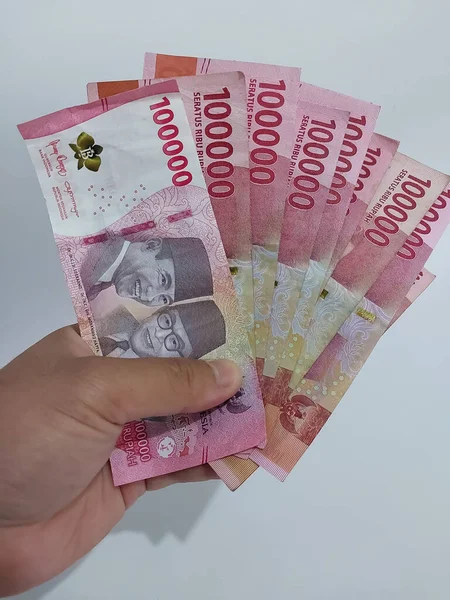 一个持有印度尼西亚卢比货币的人 10万卢比 — 图库照片