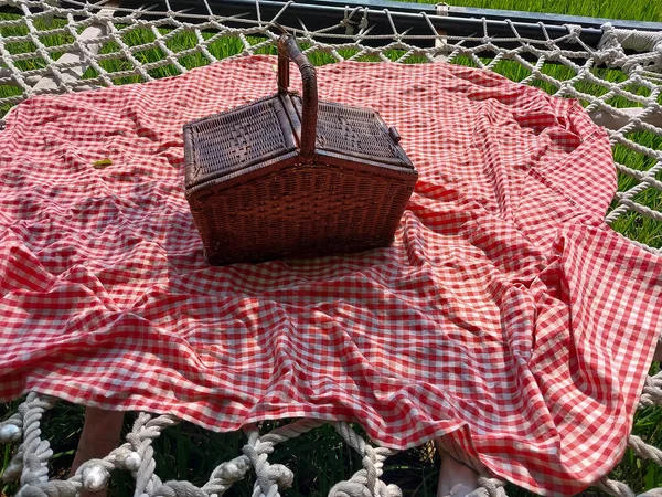 picnic table with basket of bread and basket with blanket