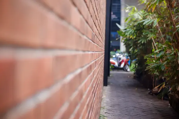 Sessiz bir sokakta soyut ve temiz kırmızı tuğla duvar dokusu.