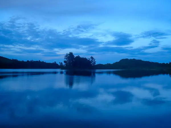 Alacakaranlıkta suda yansıması olan göl