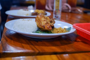 Tabaklar dolusu yemek ve kırmızı bir konteynır.