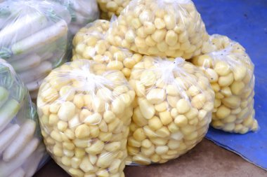 Mavi bir masanın üstünde oturan bir mısır yığını.