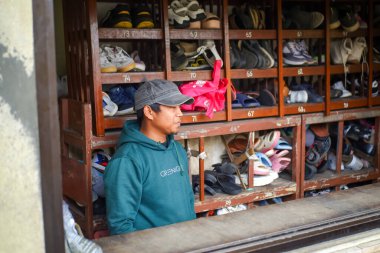 Atta 'awun Puncak Camii' nde terlik ve ayakkabı depolayan bir işçi.