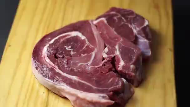 Steak Cru Dans Une Assiette Bois Sur Fond Noir — Video
