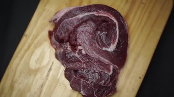 Steak Cru Dans Une Assiette Bois Sur Fond Noir — Video