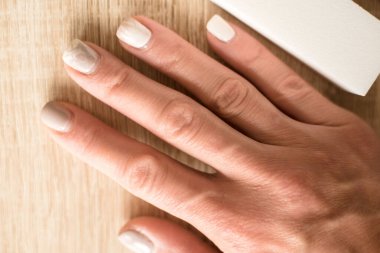 Manikür düzeltme gerektirir. Aşırı gelişmiş manikür. Tırnakları fazla büyümüş bir kadın eli. Düzeltme jeli cilası zamanı.. 