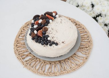 Böğürtlenli kek. Beyaz krema sürülmüş ve yaban mersini, incir, lokum ve çikolatalı mantarla süslenmiş kek.