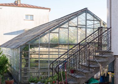 Özel sektörde camdan yapılmış bitkiler için bir sera. Bitki fidanları yetiştirmek için sera. 