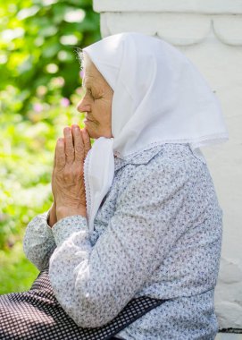 Ukraynalı son sınıf öğrencisi dua ediyor. Yaşlılık, yalnızlık. Rus saldırısı Ukrayna 'ya karşı. Yaşlı Hıristiyan kadın.