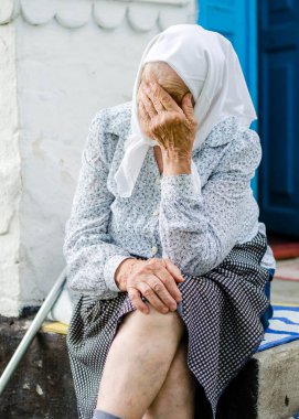 Ukraynalı yaşlı kadın evinin yakınında oturuyor. Yaşlılık, yalnızlık. Rusya 'nın Ukrayna' ya saldırısı