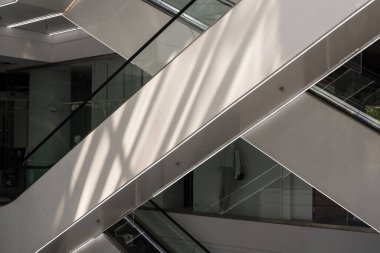 Alışveriş merkezinde modern cam asansör ve yürüyen merdiven. Boş AVM.