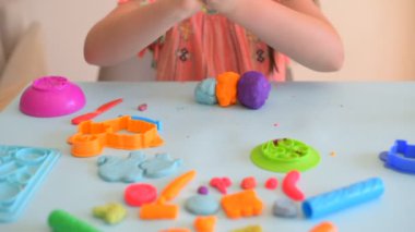 Renkli kil. Çocuk elleri renkli kille oynuyor. Plastiksin. Hamur oyna.