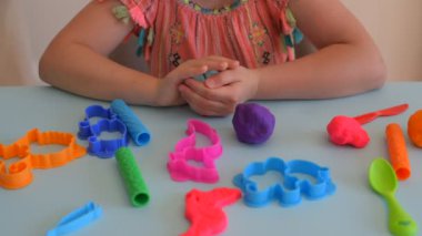 Renkli kil. Çocuk elleri renkli kille oynuyor. Plastiksin. Hamur oyna.